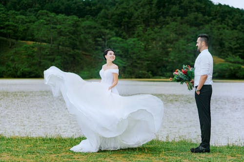 新娘站在新郎抱着花束 · 免费素材图片