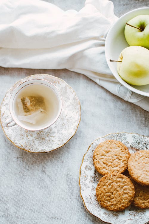 一碗苹果，一盘饼干和茶杯 · 免费素材图片