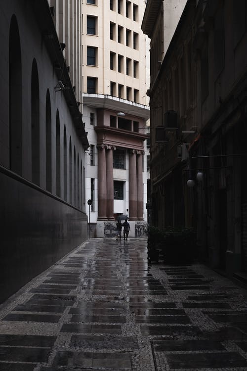 在建筑物之间行走的人 · 免费素材图片