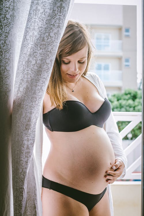 黑色内衣在阳台上的年轻孕妇 · 免费素材图片