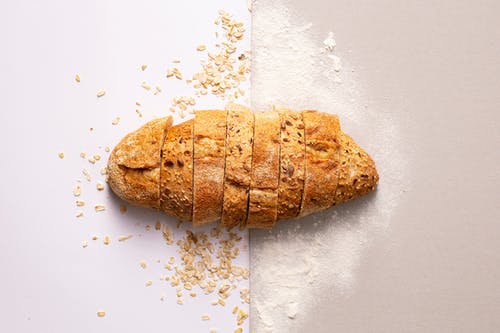 在白色表面上切面包 · 免费素材图片