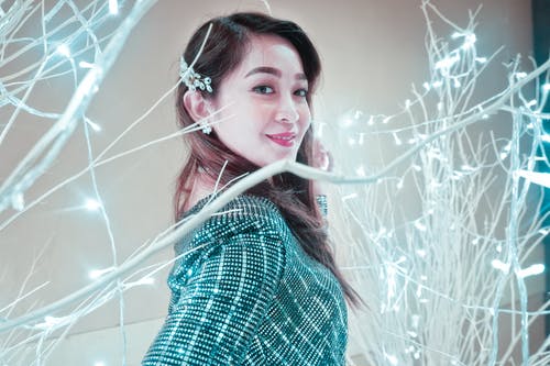 女人站在照明的植物旁边 · 免费素材图片