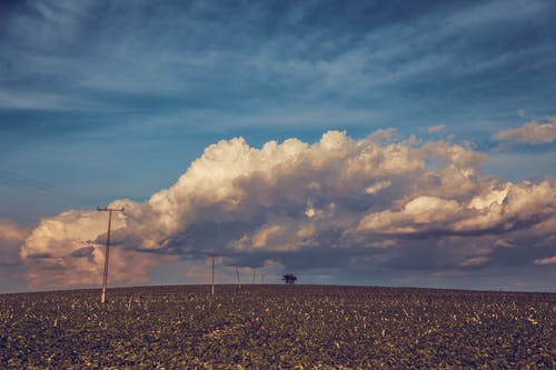 白云下的棕色公用事业岗 · 免费素材图片