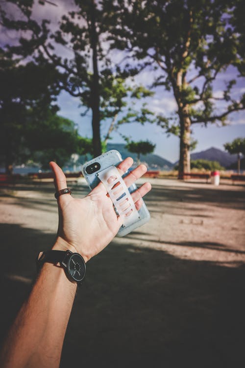 穿着灰色智能手机套的人 · 免费素材图片