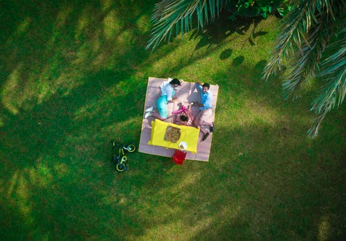 男人和女人躺在野餐垫上 · 免费素材图片