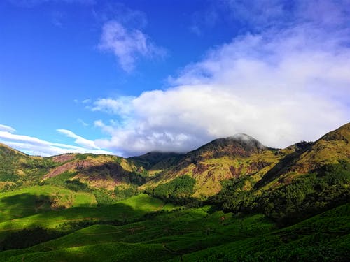 多云的天空下的绿山 · 免费素材图片