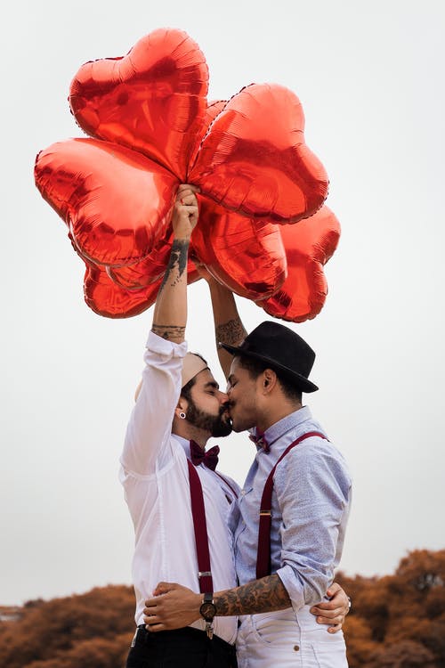 两名男子亲吻和拥抱气球 · 免费素材图片