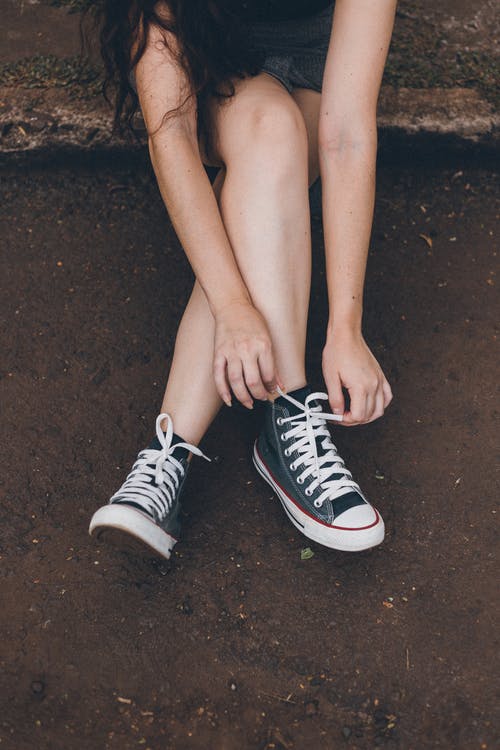 女人绑她的鞋带的照片 · 免费素材图片