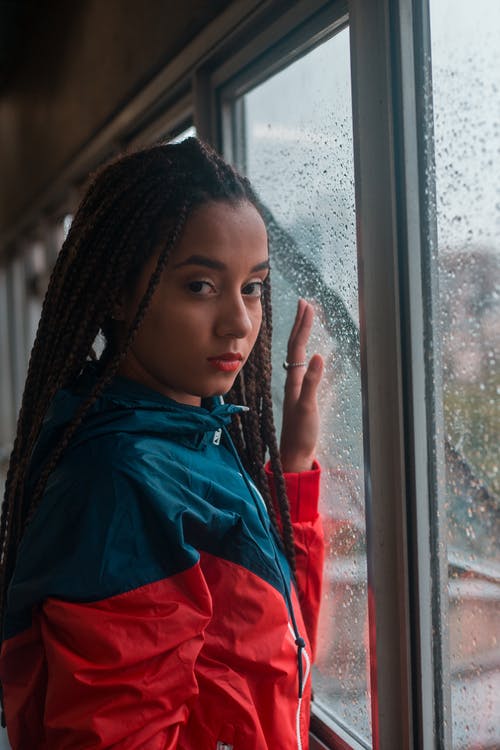 玻璃窗附近的女人穿着夹克的照片 · 免费素材图片