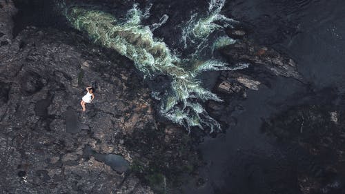 女人躺在岩石上的鸟瞰图 · 免费素材图片