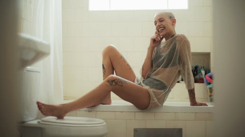微笑的女人坐在浴缸上 · 免费素材图片