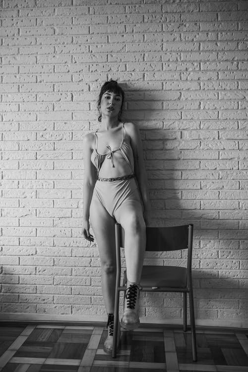 站在椅子附近的墙后面的女人 · 免费素材图片