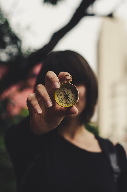 女人拿着指南针的照片 · 免费素材图片