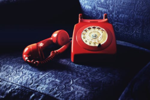 蓝色沙发上的红色旋转电话 · 免费素材图片