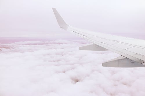 云层上方飞机机翼的照片 · 免费素材图片