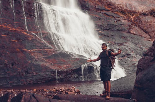 站在瀑布附近的人的照片 · 免费素材图片