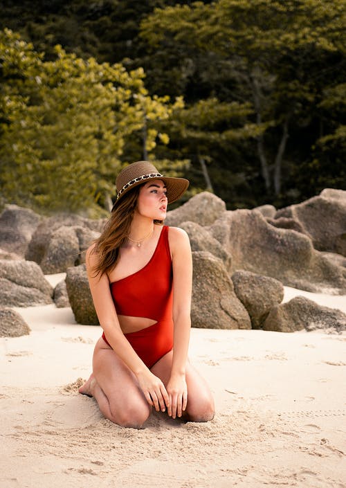跪在海边岩石附近的女人 · 免费素材图片