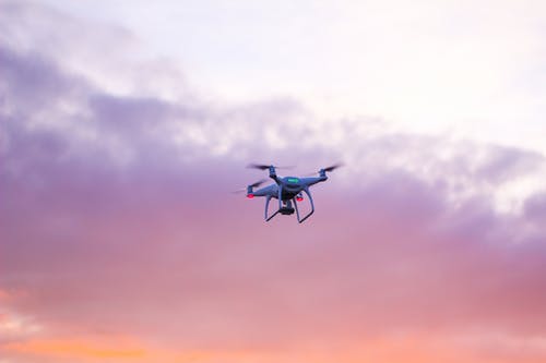 Quadcopter无人机在粉红色的天空下飞行 · 免费素材图片
