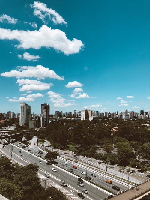 在蓝蓝的天空下的道路上行驶的汽车 · 免费素材图片