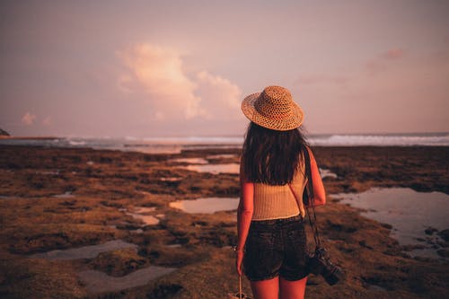女人站在海边面对水体的选择性焦点摄影 · 免费素材图片