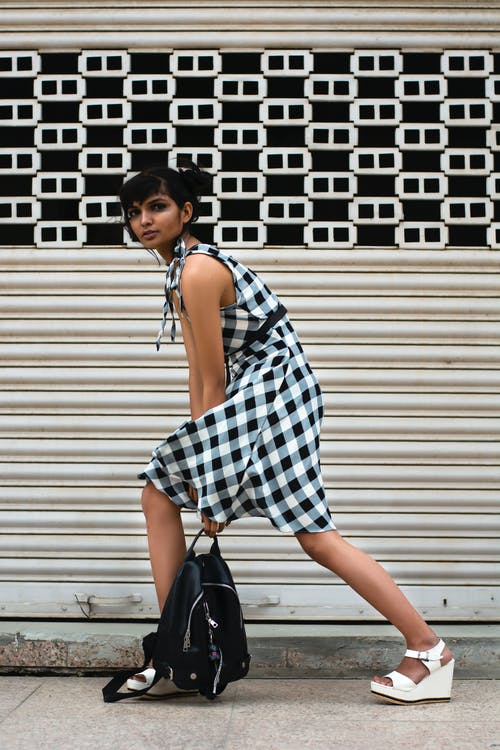 站在白色的卷帘门前的女人 · 免费素材图片