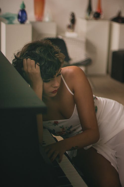 女人右臂靠在钢琴上 · 免费素材图片