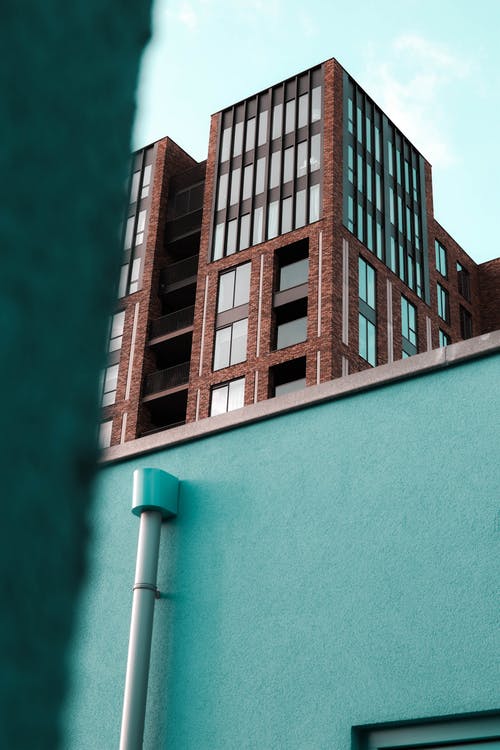 白云下的棕色和绿色建筑 · 免费素材图片