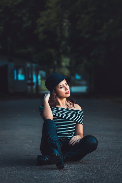 坐在人行道上的女人 · 免费素材图片