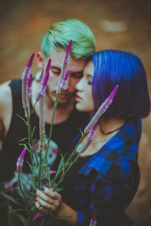 男人和女人拥抱而女人手捧紫色花 · 免费素材图片
