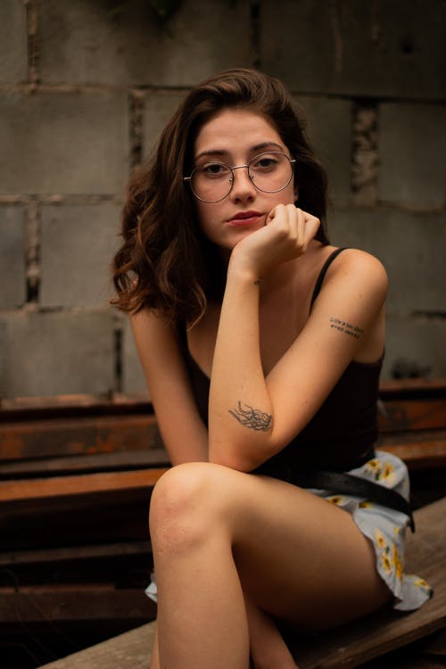 女人坐在棕色的木板上 · 免费素材图片