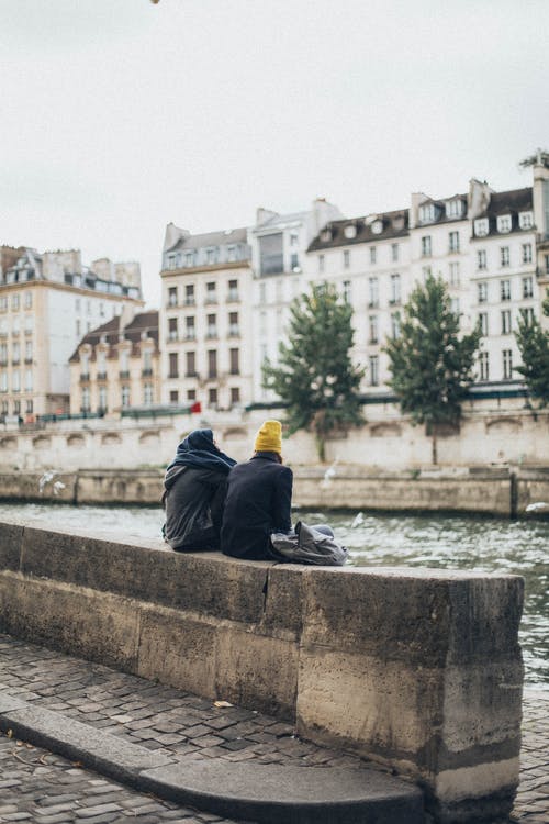 男人和女人坐在河边 · 免费素材图片