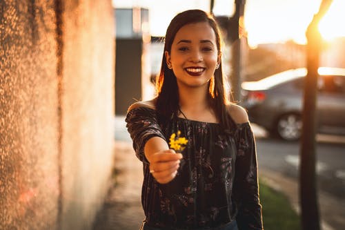 微笑的女士拿着黄色的花瓣 · 免费素材图片