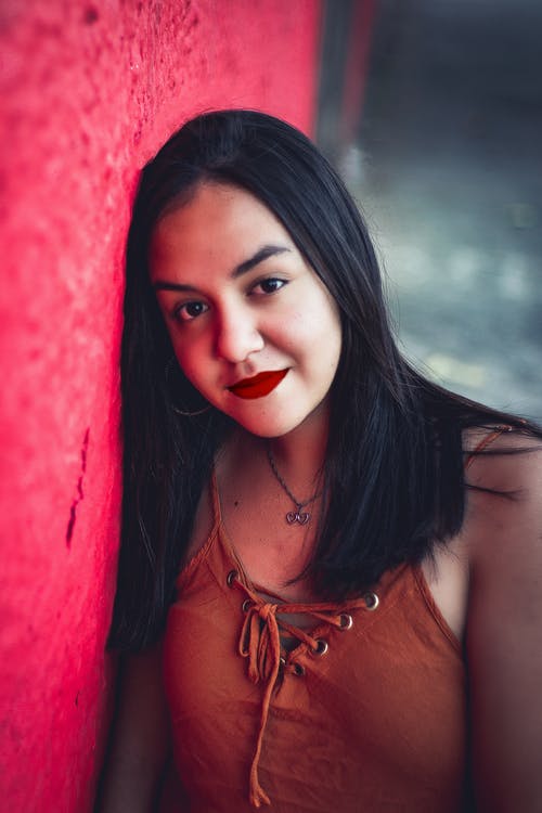 微笑的女人靠在红色的沃尔 · 免费素材图片