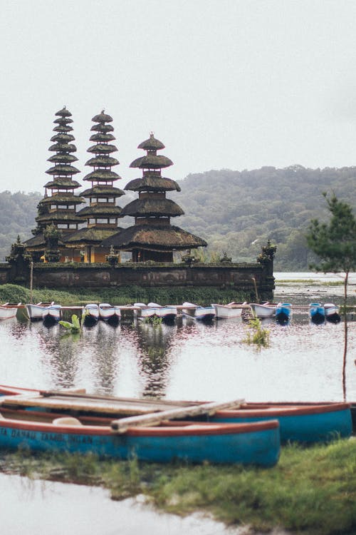 船在水体旁边的灰色神庙 · 免费素材图片