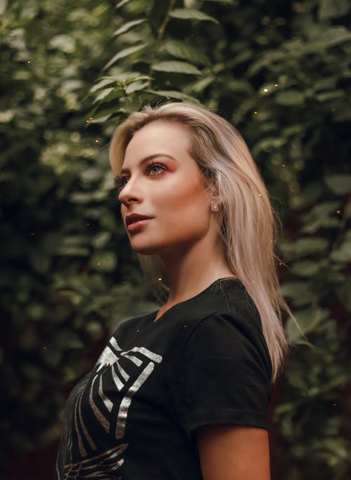黑色圆领t恤站在绿树旁的女人 · 免费素材图片
