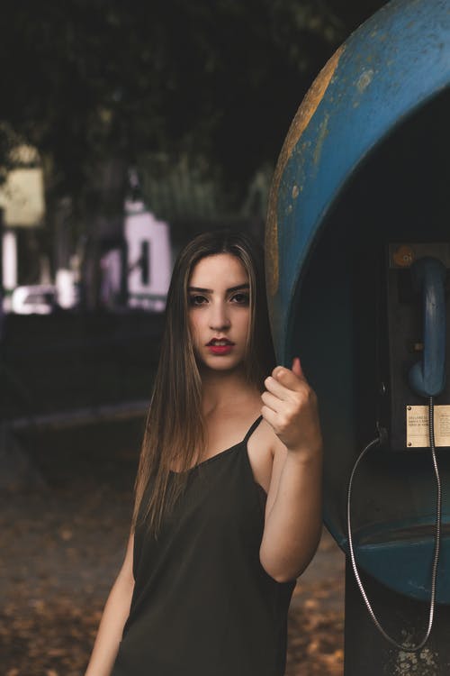 女人靠在电话亭 · 免费素材图片