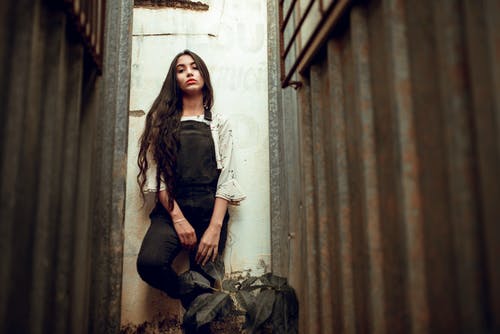 黑色工作服站在墙上的女人 · 免费素材图片