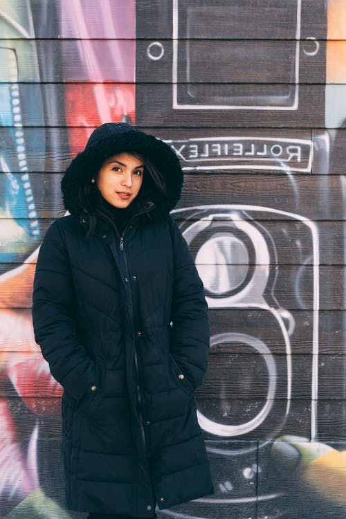 涂鸦墙前穿冬季夹克的女人 · 免费素材图片