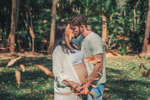 孕妇和男人亲吻树的前面 · 免费素材图片