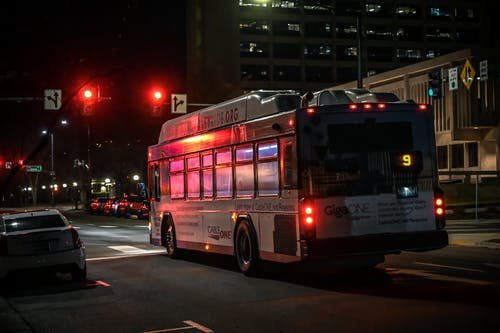 红色交通灯附近道路上的白色c型房车 · 免费素材图片