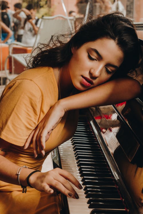 她的头躺在钢琴上的女人 · 免费素材图片