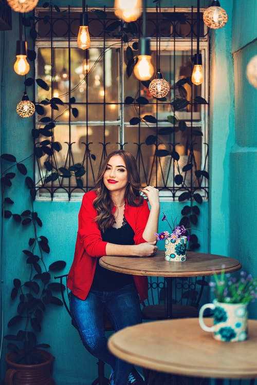 微笑着坐在餐桌旁的女人 · 免费素材图片