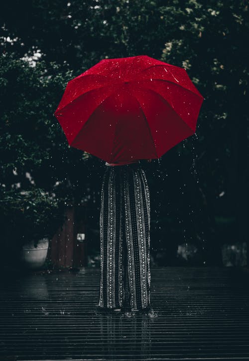 站立使用红色伞的人 · 免费素材图片