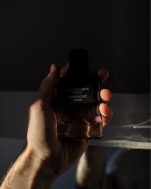 纪梵希（Givenchy）捧着绅士专用古龙水瓶的照片 · 免费素材图片