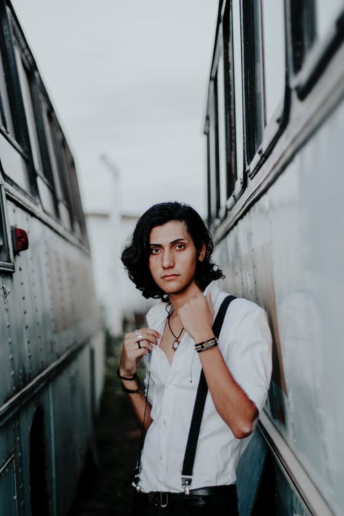 男子站在公共汽车之间 · 免费素材图片