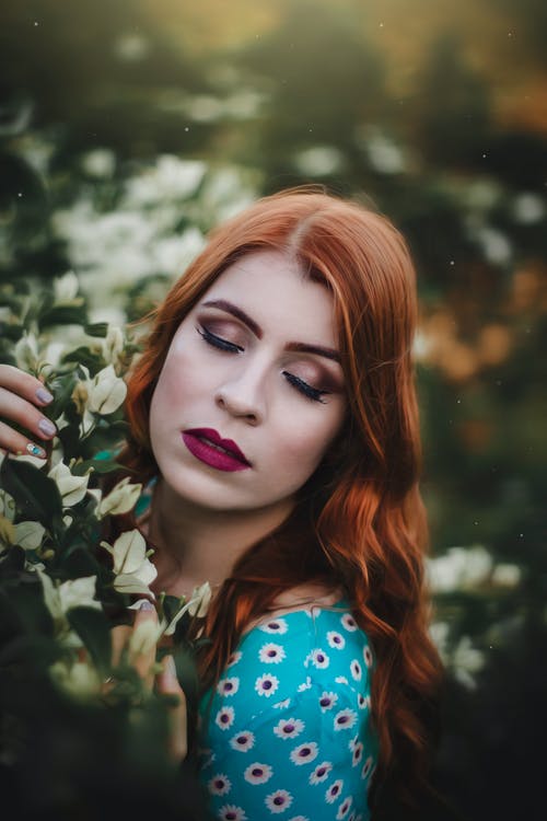 女人靠近花的选择性聚焦摄影 · 免费素材图片