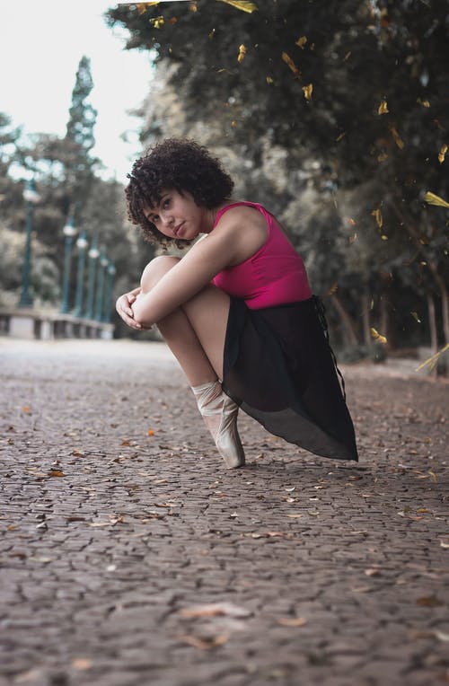 坐在绿色和棕色树旁边的芭蕾舞女演员 · 免费素材图片