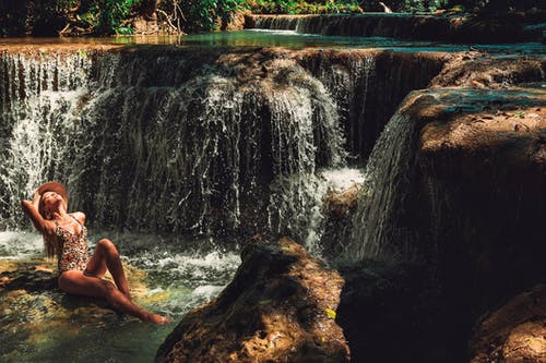 坐在瀑布附近的女人 · 免费素材图片