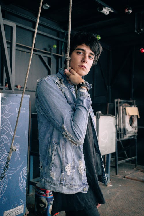 男子身穿牛仔夹克抓绳子 · 免费素材图片