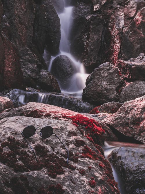 黑色嬉皮太阳镜在岩石上 · 免费素材图片
